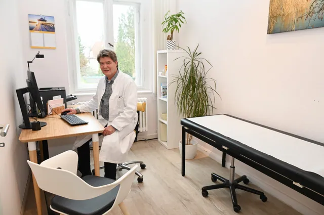 Ärztin am Schreibtisch im Behandlungszimmer