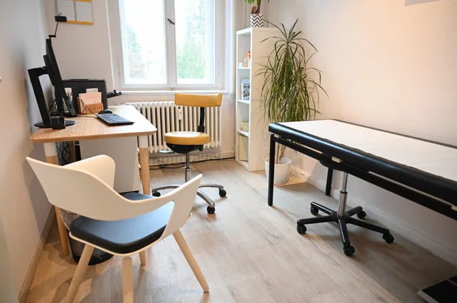 Behandlungszimmer mit Schreibtisch und Liege
